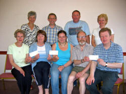 Pictured at the presentation of cheques at Magheragall Parish Church on Saturday 10th June is: L to R: (front) Elizabeth Park, Gerardine Tolerton, Kerri Cunningham, and the Rector, the Rev Nicholas Dark. (back row) Gill Colvin, Ian Park, Bobby Cunningham and Sharon Cunningham.