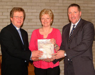 The Rector, the Rev Nicholas Dark, presents a gift to Bobby and Sharon Cunningham in recognition of their exemplary leadership of Magheragall Parish Senior Citizens' Club, which celebrated its 20th anniversary with a dinner last Wednesday afternoon (31st January).