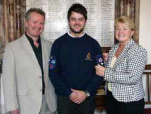 Jamie McCutcheon receives the Queen's Badge from his mother Jayne. Looking on is Jamie's father Seamus. 