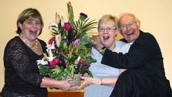 Canon Cochrane joins in the fun as his wife Mildred is presented with a gift on behalf of the congregation by Mrs Ann Elliott - People?s Warden.