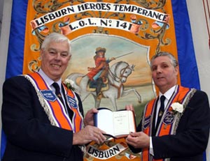 Bro Jim Martin, Worshipful Master of LOL 141, presents a Bible to Bro Robert Orr, Past District Master of Lisburn District LOL No 6.