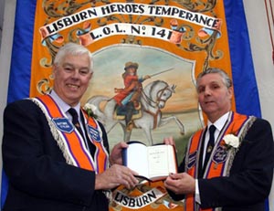 Bro Jim Martin, Worshipful Master of LOL 141, presents a Bible to Bro Robert Orr, Past District Master of Lisburn District LOL No 6.