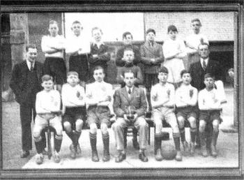 1937 Hilden PS winning the Schools Cup. Back (l-r) Harry Rooney, Jack Johnston, Harry McClurg, Billy Dornan, Harry McGuiness, Jim Gorman, John O'Kane. Middle (l-r) Mr Clarke (teacher) Jack Shankey (Goals) Paddy Toman (Trainer). Front (l-r) Kenny Fryer, Billy Hanna, Harry McKitterick, Him Barbour, Tommy McGuinness (Captain), Tommy Toman, Freddy Gorman (Lawrence Close is sneaking a quick peak around the corner)