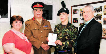 Simon receiving his certificate from Colonel McAllister while proud mum and dad, Tracy and William, add their congratulations.