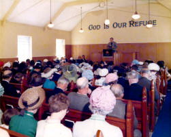 A very young Rev. William Beattie pictured in 1978 conducting a service in a small hall on the Glenburn Road prior to the opening of the present church at Seymour Hill.