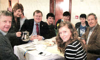 Left to right Jonathan Gibson, Naomi Barr (serving tea), Jonathan Craig MLA, Steven Kane, Timothy Gibson, Nathan Craig, Councillor Uel Mackin, Amy Gibson.