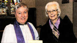 Mrs. Betty McClean (People's Churchwarden) pictured presenting a gift to the Rev Raymond Devenney on behalf of the parishioners